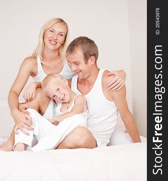 Happy family, mother ,father and their son on the bed at home. Happy family, mother ,father and their son on the bed at home