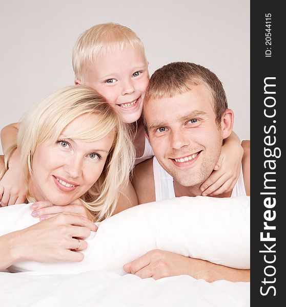 Happy family; mother ,father and their son in  bed at home. Happy family; mother ,father and their son in  bed at home