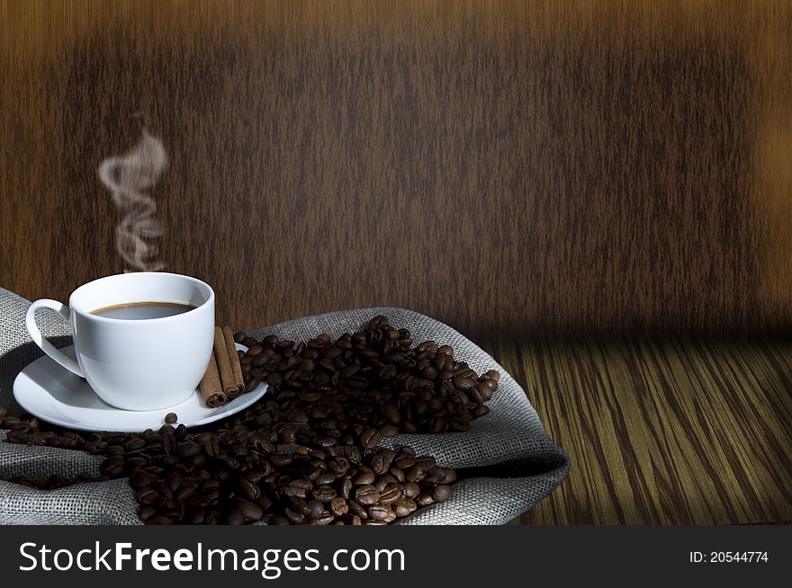 Cup of coffee and coffee beans on the Sacking, abstract grunge background. Cup of coffee and coffee beans on the Sacking, abstract grunge background