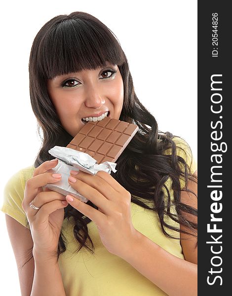 A young pretty woman biting into a block of fruit and nut fine chocolate. White background. A young pretty woman biting into a block of fruit and nut fine chocolate. White background.