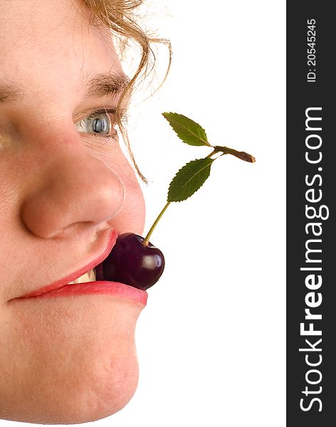 Young woman holding cherry in mouth on white background