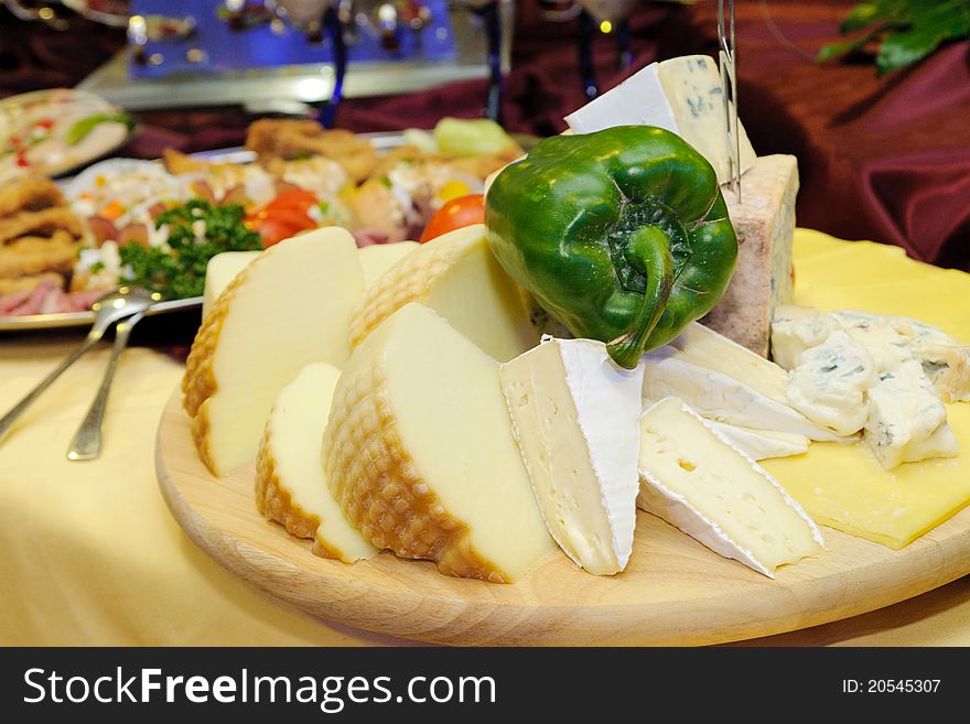 Group of cheeses with green pepper garnished on the chopping board. Group of cheeses with green pepper garnished on the chopping board.