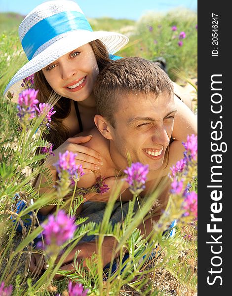 Portrait of beautiful young couple lying on grass - Outdoor