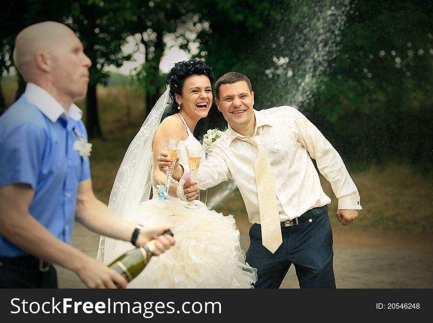 Young man opens sparkling wine and splashing on wedding