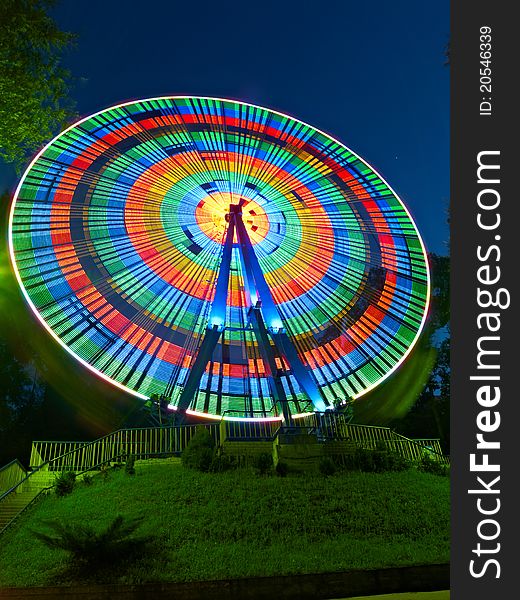 Wheel spinning at night and the lights are merged into multi-colored circles. Wheel spinning at night and the lights are merged into multi-colored circles.