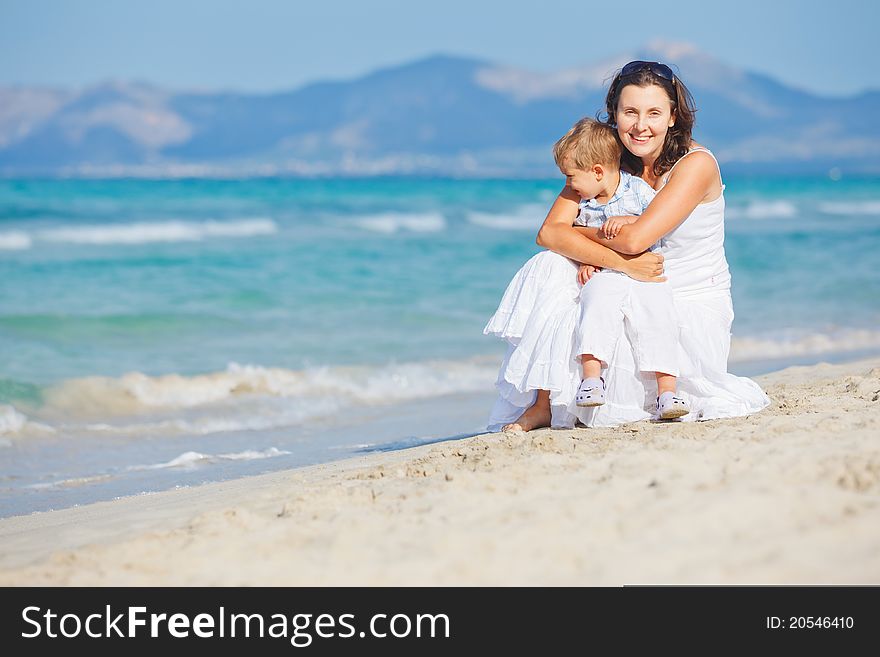 Young Mother With Her Son On Beach Vacation