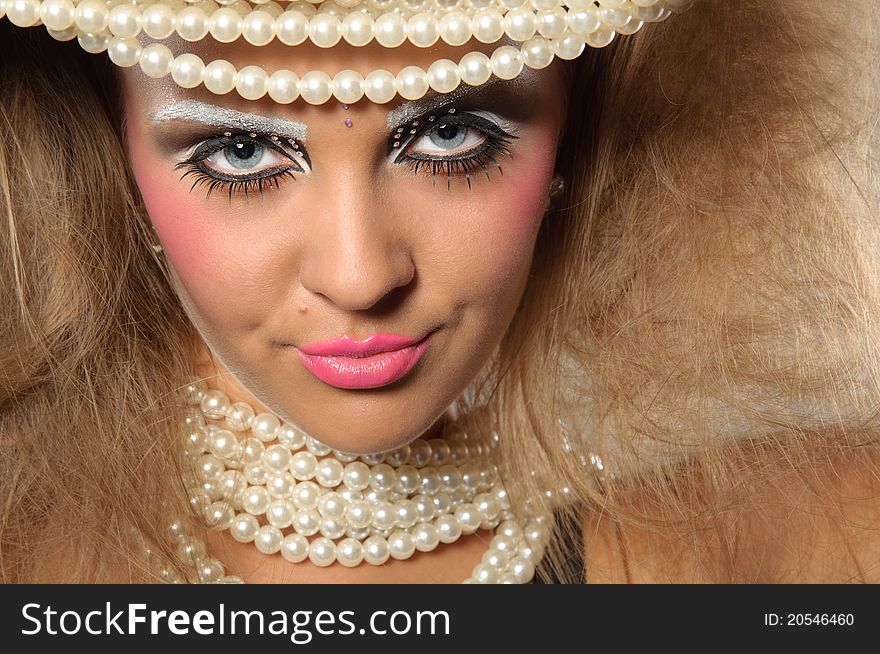 Girl with a professional makeup and pearl beads