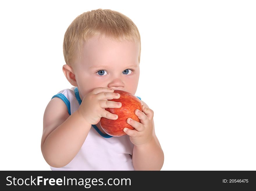 Child, a boy, he eats an apple, holding it with both hands