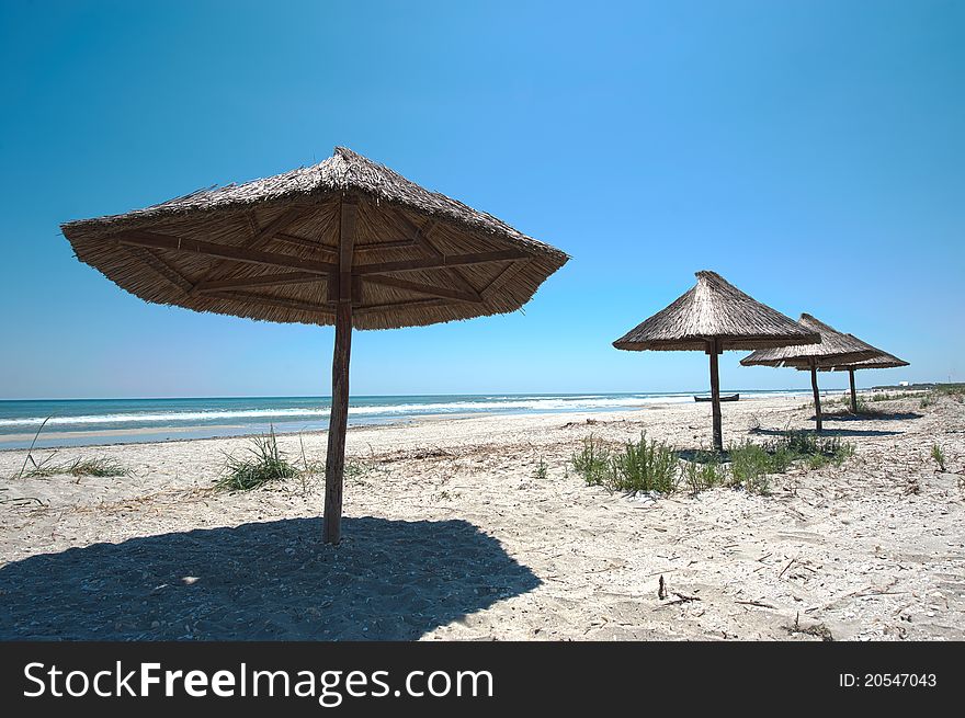 Empty beach with wooden umbrellas