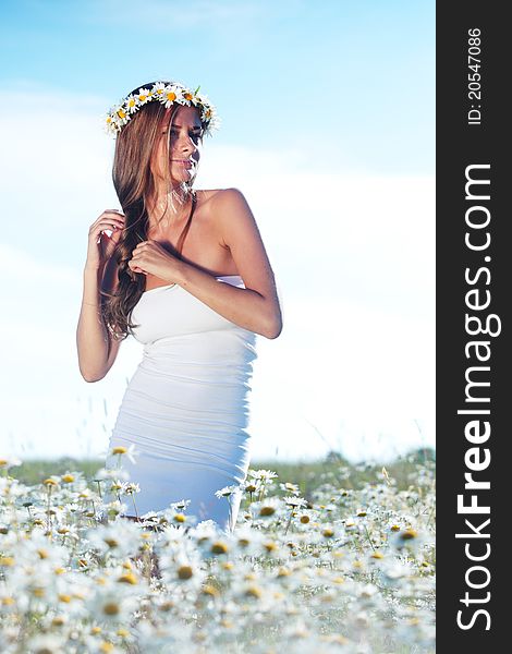 Girl in dress on the daisy flowers field