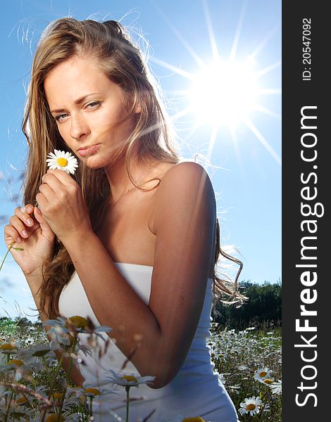 Beautiful girl in dress on the sunny daisy flowers field. Beautiful girl in dress on the sunny daisy flowers field