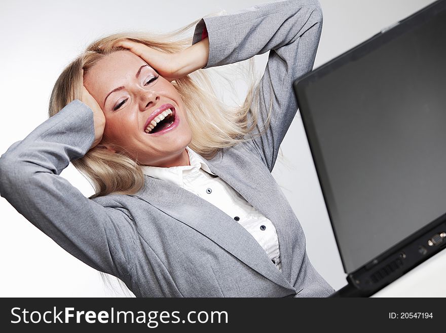 Laughing business woman working on laptop