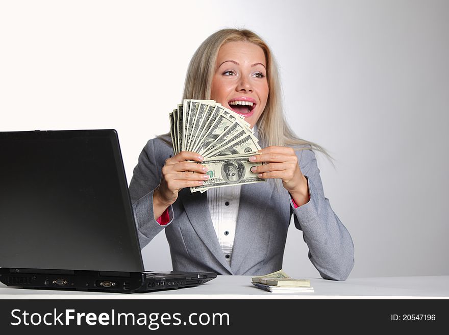 Business woman working on laptop dollar in hands. Business woman working on laptop dollar in hands