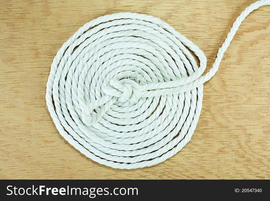 White rope coiled on the surface of the wood.