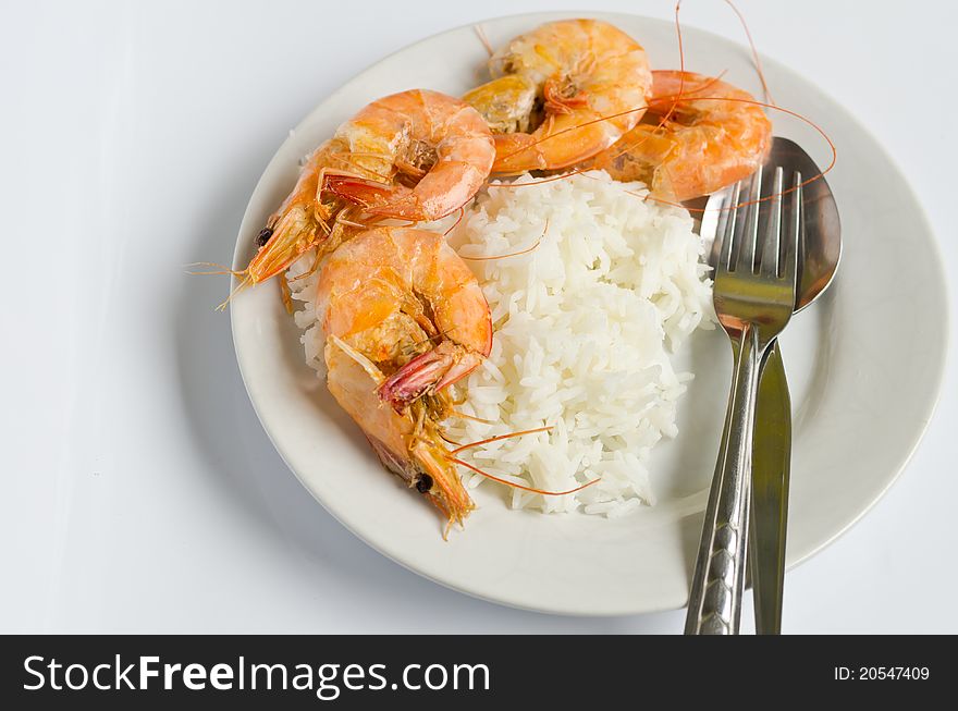 Baked shrimp with rice on white dish, ready to eat