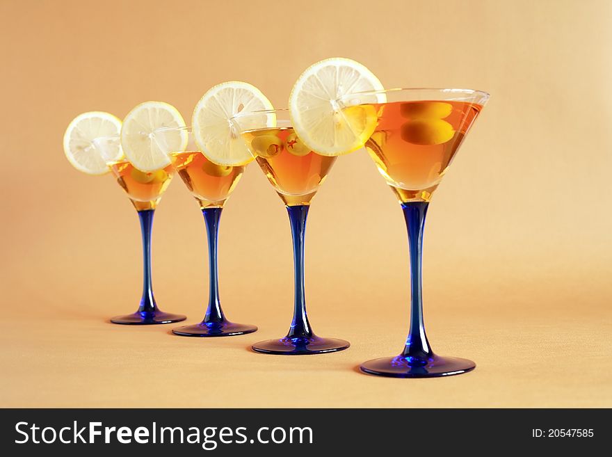 Four martini glasses with lemon and olives standing in a row. Four martini glasses with lemon and olives standing in a row