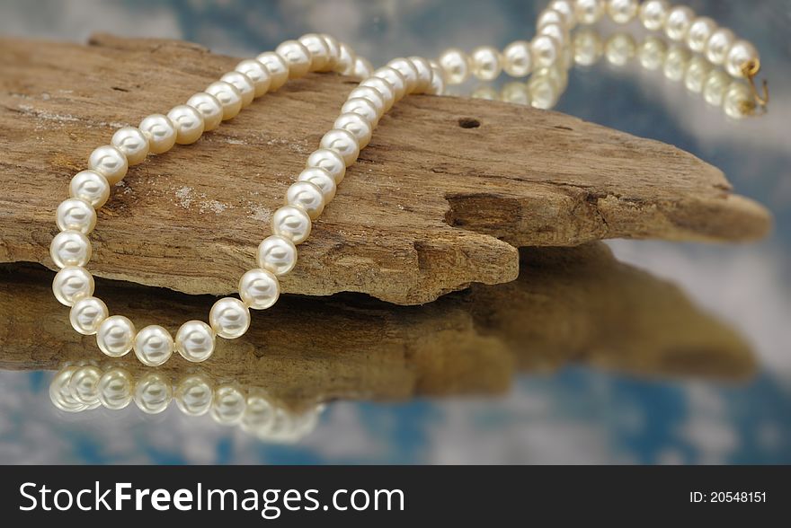 Elegant pearls with sky, drift wood, and reflection very shallow depth of field
