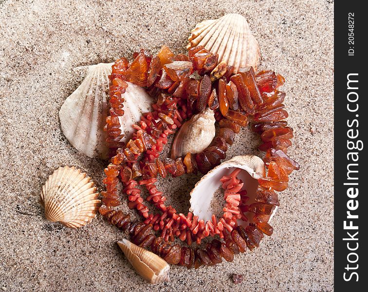 Amber necklace with shells on the beach. Amber necklace with shells on the beach.