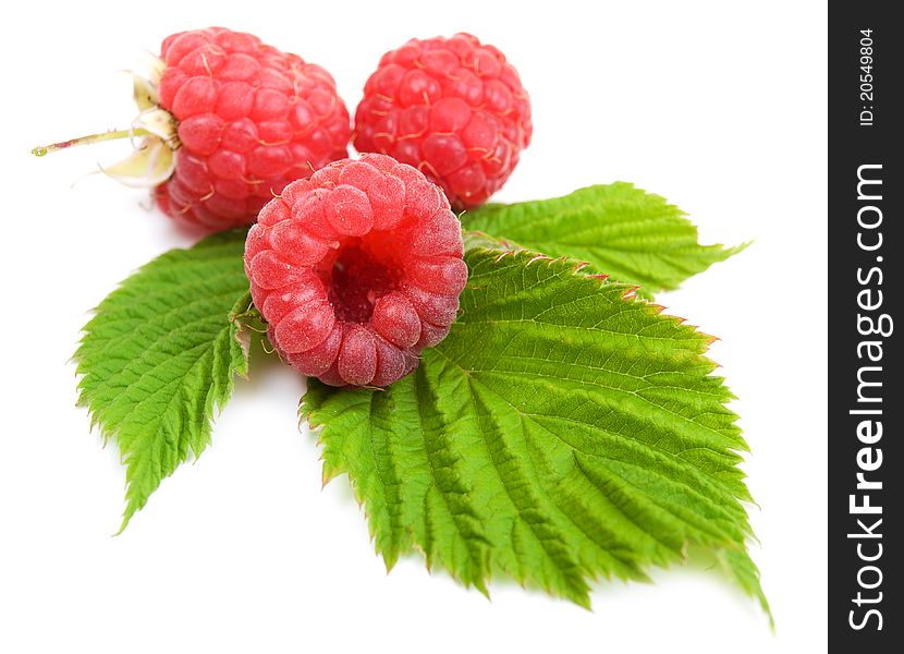 Raspberries with green leaves on a white background