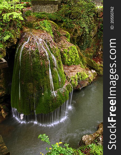 Beautiful waterfall falling off a rock covered with moss