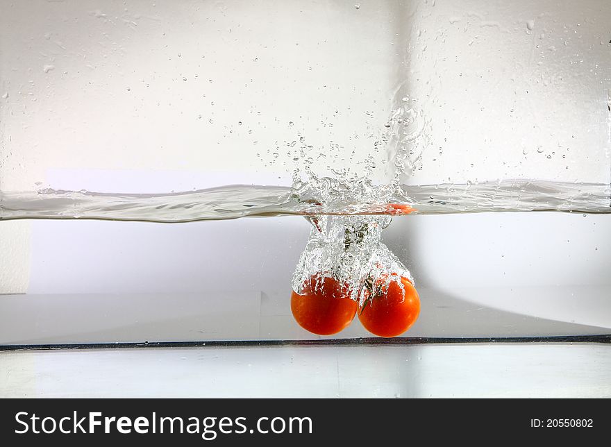 Bunch of tomatoes falling in water