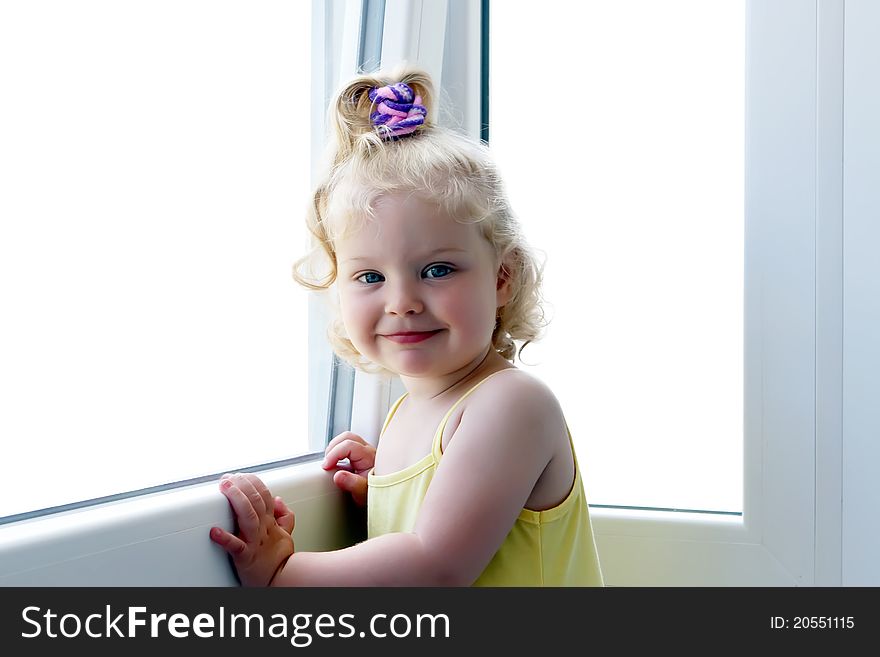 Little smiling caucasian girl near the windows. Little smiling caucasian girl near the windows