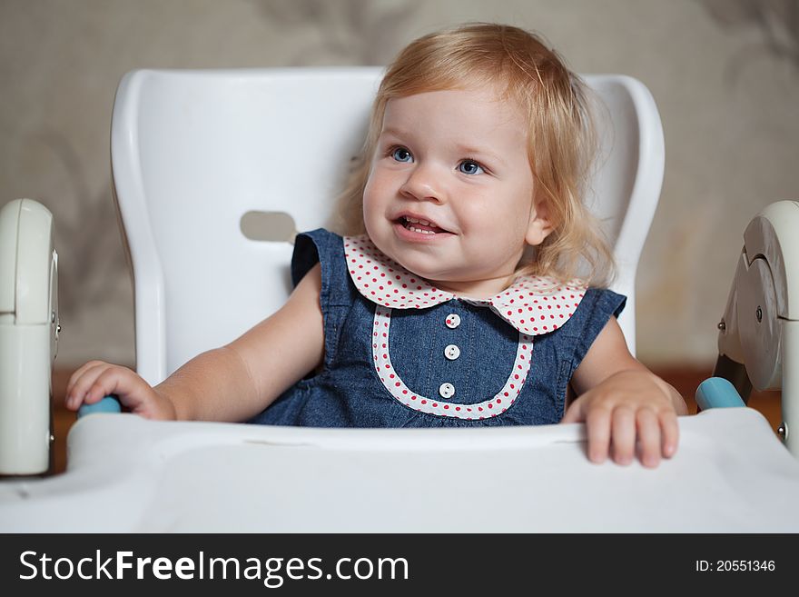 Little Girl Sitting At The Table And Looking Left