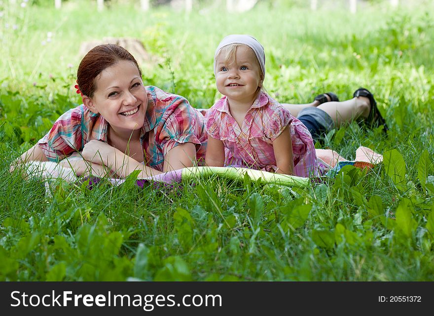 Mother And Daughter Lying In The Grass