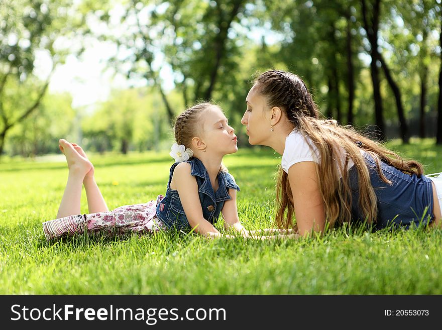 Mother with her daughter outside in the summer park