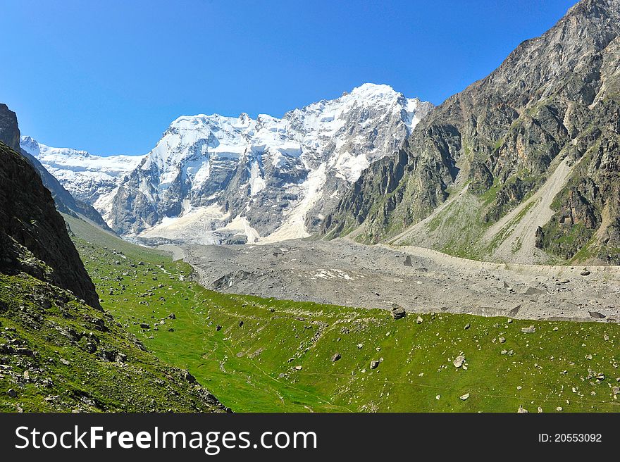 Mountain landscape with green field and stones