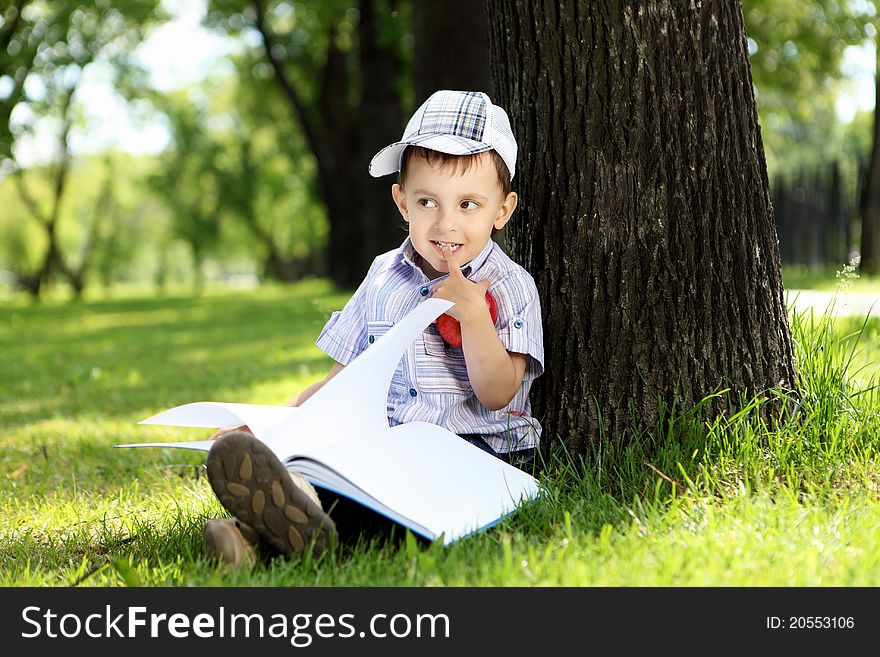 Portrait of a boy with a book in the park