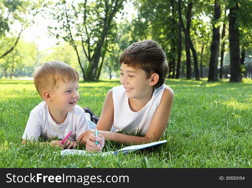 Children In The Park Reading A Book