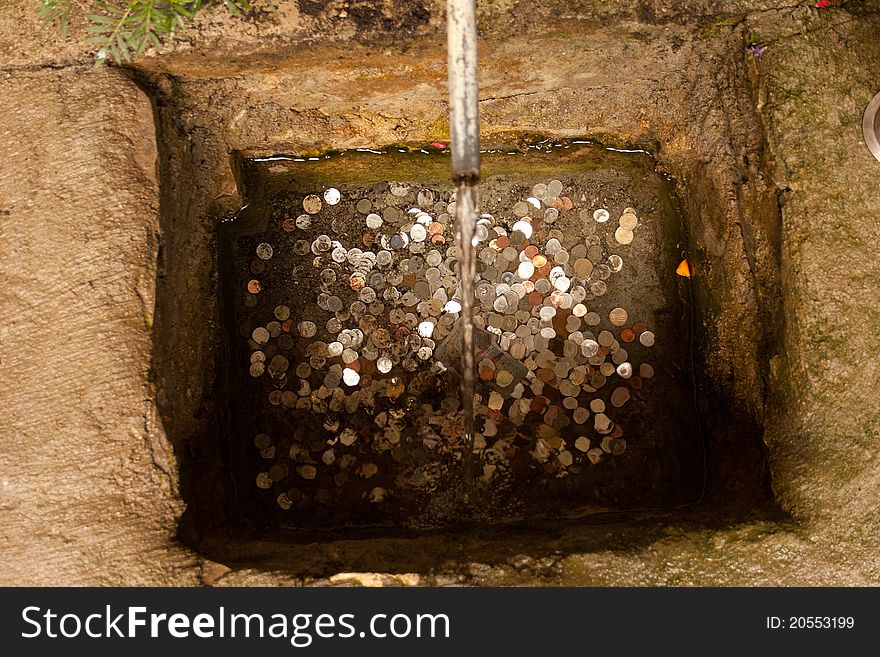 A little well with coins and water