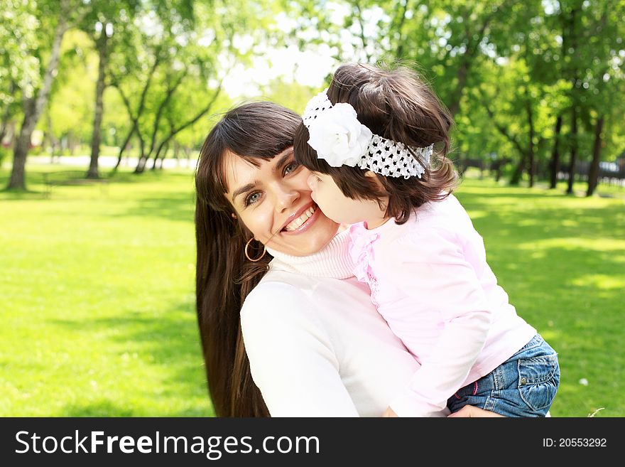 Mother with her daughter outside in the summer park