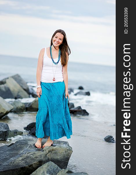 Beautiful smiling woman stands against the ocean