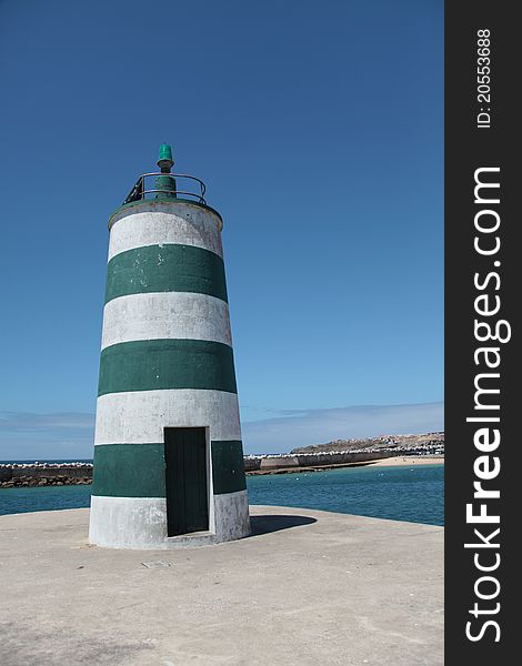 Light house with white and green stripes based in Portugal in Peniche beach. Light house with white and green stripes based in Portugal in Peniche beach