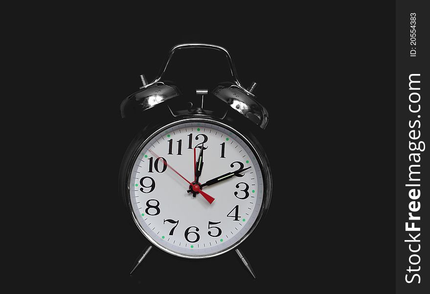 Metal alarm-clock on black background