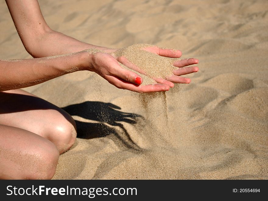 Hands with red nails in the sand. Hands with red nails in the sand.