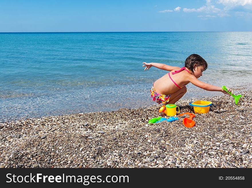 Little girl playing with toys on the beach. Little girl playing with toys on the beach