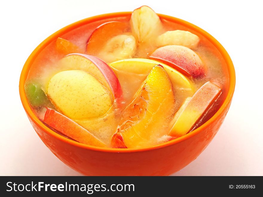 Orange bowl with frozen fruits and water. Orange bowl with frozen fruits and water