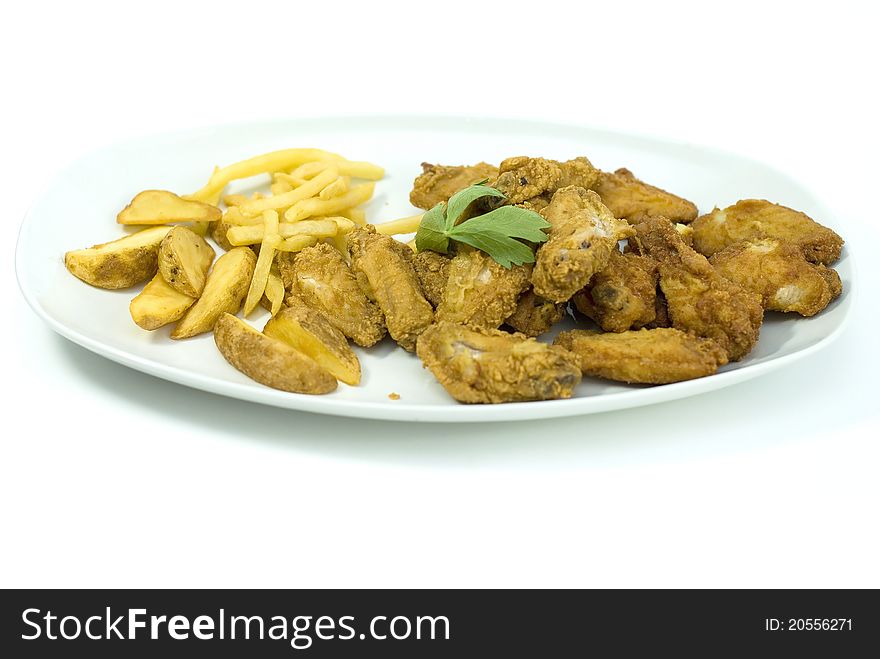 Golden fried chicken and fried potatoes in a white plate