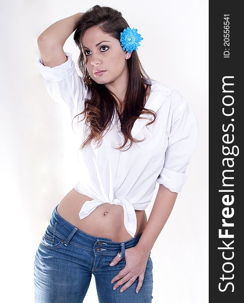 Isolated woman on a white background, dressed in jeans and shirt, with blue flowers