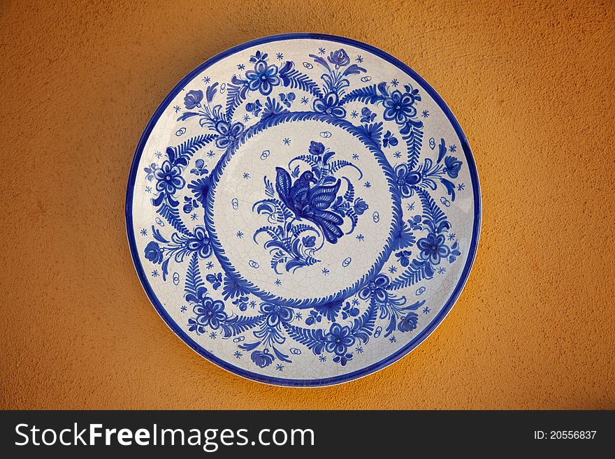 Spanish traditional ceramic plate on an orange wall