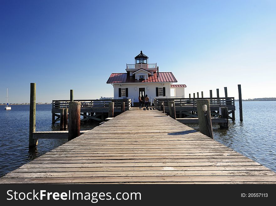 A light house from North Carolina coast with wooden boardwalk in sunny day. A light house from North Carolina coast with wooden boardwalk in sunny day
