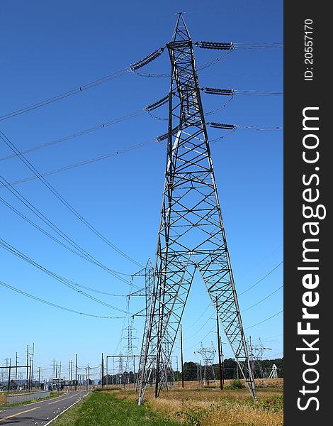 Tall towers distributing power-lines to various directions in an open field. Tall towers distributing power-lines to various directions in an open field.