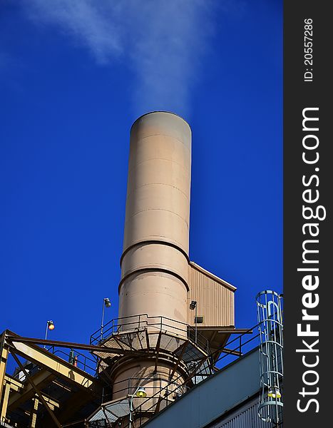 A smokestack of a coal power plant and blue sky