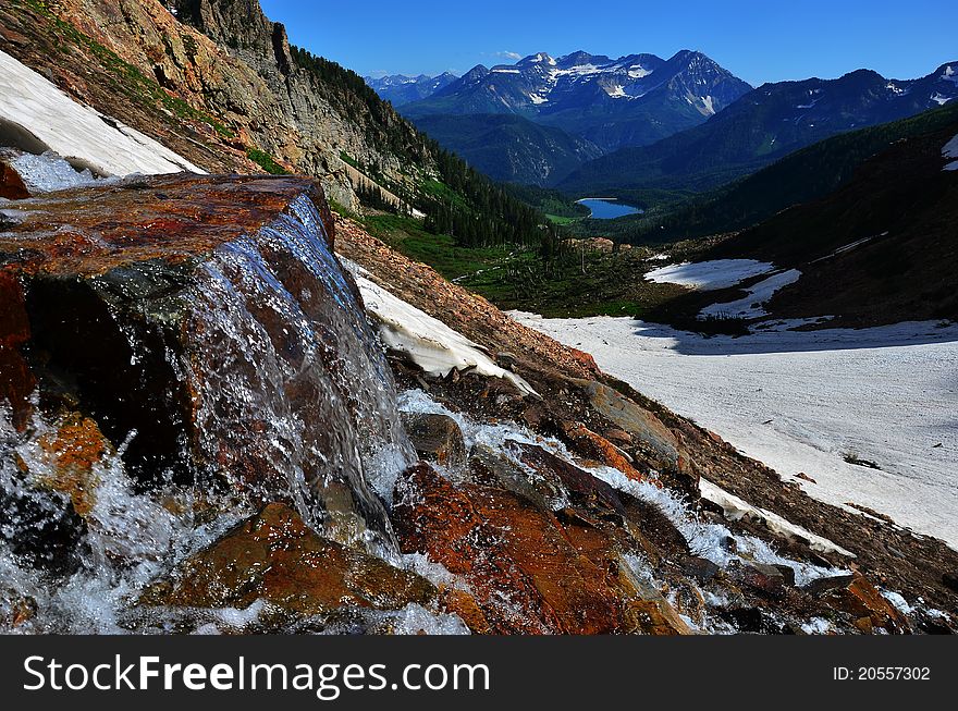 A waterfall with snow, mountains and a beautiful lake. A waterfall with snow, mountains and a beautiful lake