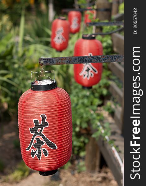 Red lanterns on wooden bridge, with Chinese letters tea printed, which is a Chinese traditional culture. Red lanterns on wooden bridge, with Chinese letters tea printed, which is a Chinese traditional culture.