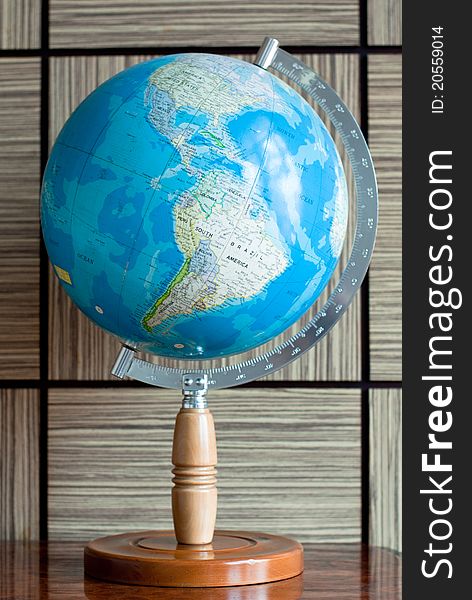 A blue earth globe on a wooden stand with latitude degree scale. A blue earth globe on a wooden stand with latitude degree scale