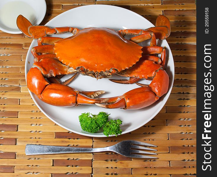 This is a dish of delicious crab, rosy and, green broccoli ornament on it,Fork in the front. This is a dish of delicious crab, rosy and, green broccoli ornament on it,Fork in the front.